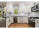 Galley kitchen features white cabinets, stainless steel appliances, granite countertops, and tile backsplash at 4272 Glenlake Nw Dr, Kennesaw, GA 30144