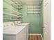 Efficient laundry room with washer, dryer, and ample shelving for organized storage at 4272 Glenlake Nw Dr, Kennesaw, GA 30144