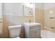 Bathroom with a vanity sink, mirror, and tiled walls at 851 Rockbridge Sw Rd, Lilburn, GA 30047
