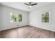Bedroom features wood-look floors, neutral paint and two windows allowing ample light at 851 Rockbridge Sw Rd, Lilburn, GA 30047