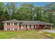 Charming brick home with white shutters, complemented by a spacious carport and lush front yard at 851 Rockbridge Sw Rd, Lilburn, GA 30047