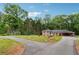 Inviting single-Gathering home featuring a brick exterior, mature trees, and a circular driveway for easy access at 851 Rockbridge Sw Rd, Lilburn, GA 30047