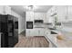 Modern kitchen with white cabinets, stainless steel appliances, granite countertops, and wood-look flooring at 851 Rockbridge Sw Rd, Lilburn, GA 30047
