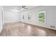 Bright and airy living room featuring hardwood floors, modern ceiling fan, and large windows at 851 Rockbridge Sw Rd, Lilburn, GA 30047