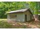 Weathered shed featuring a ladder, with an open door in wooded lot at 851 Rockbridge Sw Rd, Lilburn, GA 30047