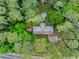 Aerial view of home showing an in-ground pool surrounded by many trees at 881 Rockbridge Sw Rd, Lilburn, GA 30047