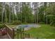 Backyard featuring an in-ground pool surrounded by lush greenery and trees at 881 Rockbridge Sw Rd, Lilburn, GA 30047