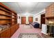 Finished basement with built-in shelving, a brick fireplace, and comfortable seating on neutral carpeting at 881 Rockbridge Sw Rd, Lilburn, GA 30047