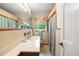 Cozy bathroom featuring a vanity with a large mirror, a window, and a shower at 881 Rockbridge Sw Rd, Lilburn, GA 30047