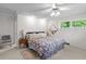Bedroom with carpeted floors, one window, ceiling fan, neutral walls, and a small table at 881 Rockbridge Sw Rd, Lilburn, GA 30047