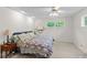 Bright bedroom featuring neutral carpet, a ceiling fan, and a comfortable bed near a side table with a lamp at 881 Rockbridge Sw Rd, Lilburn, GA 30047