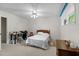 Bright bedroom featuring neutral carpet, a ceiling fan, and a comfortable bed near a work desk at 881 Rockbridge Sw Rd, Lilburn, GA 30047