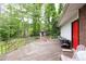 Spacious wooden deck with railings and a red door leading to the lush backyard at 881 Rockbridge Sw Rd, Lilburn, GA 30047