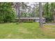Charming single-story home featuring a well-manicured lawn and mature trees at 881 Rockbridge Sw Rd, Lilburn, GA 30047
