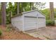 Two-car metal garage with two roll up doors and concrete walkway at 881 Rockbridge Sw Rd, Lilburn, GA 30047