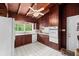 Cozy kitchen with wood ceiling, white appliances, wood cabinets, and ample natural light at 881 Rockbridge Sw Rd, Lilburn, GA 30047