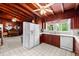 Spacious kitchen featuring wood ceiling, white appliances, and natural light at 881 Rockbridge Sw Rd, Lilburn, GA 30047