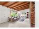 Open living room with exposed wood beam ceilings, brick accent wall and natural light at 881 Rockbridge Sw Rd, Lilburn, GA 30047