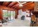 Open living room with brick fireplace and access to sunroom and kitchen at 881 Rockbridge Sw Rd, Lilburn, GA 30047
