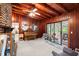 Relaxing living space with brick fireplace, piano, and view of the sunroom at 881 Rockbridge Sw Rd, Lilburn, GA 30047
