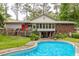 Backyard view of a house with a large deck, screened in porch, and a filled swimming pool at 881 Rockbridge Sw Rd, Lilburn, GA 30047