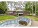 Backyard view of a house with a large deck, screened in porch, and an empty swimming pool at 881 Rockbridge Sw Rd, Lilburn, GA 30047