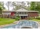 Backyard view of a house with a large deck, screened in porch, and an empty swimming pool at 881 Rockbridge Sw Rd, Lilburn, GA 30047