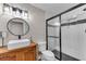 Modern bathroom featuring wood vanity, a glass enclosed shower, and a round mirror at 10005 Lakeview Pkwy, Villa Rica, GA 30180