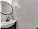 Cozy powder room featuring a unique vessel sink, dark wood vanity, and round mirror at 10005 Lakeview Pkwy, Villa Rica, GA 30180