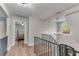 Upstairs hallway with an overlook into a bedroom and a window with natural light at 10005 Lakeview Pkwy, Villa Rica, GA 30180