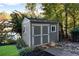 Well-maintained storage shed in the backyard, surrounded by lush greenery and landscaping at 10005 Lakeview Pkwy, Villa Rica, GA 30180
