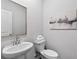 Bathroom with white pedestal sink and toilet, plus a decorative painting on the wall at 1385 Vayda Ct, Marietta, GA 30066