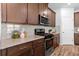 Close-up of a kitchen with dark wood cabinets and stainless steel gas range oven at 1385 Vayda Ct, Marietta, GA 30066