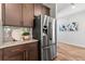 A stainless steel refrigerator in a kitchen with dark wood cabinets and a countertop at 1385 Vayda Ct, Marietta, GA 30066