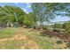 Community playground with green grass, mature trees, and a black fence at 1385 Vayda Ct, Marietta, GA 30066