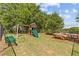 Playground with swings, slide, playhouse, and benches; partially shaded by mature trees at 1385 Vayda Ct, Marietta, GA 30066