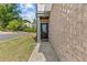 Side entrance of home with brick facade, storm door, manicured lawn, and charming walkway at 1385 Vayda Ct, Marietta, GA 30066