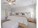 Spacious main bedroom showcasing a ceiling fan, nightstands, a bed, and an upholstered bench at 2851 Fareed St, Douglasville, GA 30135