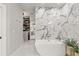 The sleek bathroom features a modern tub, marble walls, and a walk-in closet at 3290 Camellia Ln, Suwanee, GA 30024