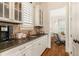 Butler's pantry with granite counters, stone backsplash, and modern cabinets near the open doorway at 3290 Camellia Ln, Suwanee, GA 30024
