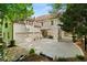 Exterior of home with stone patio, covered porch, a long driveway, and basketball hoop at 3290 Camellia Ln, Suwanee, GA 30024