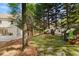 Backyard stone patio with fire pit and comfortable seating, surrounded by trees and landscaping at 3290 Camellia Ln, Suwanee, GA 30024