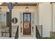 Elegant entryway features a dark wood door with glass panels, black iron railings and beautiful decorative accents at 3290 Camellia Ln, Suwanee, GA 30024