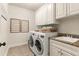 Bright laundry room featuring a sink, a washer and dryer, granite countertops, and convenient cabinet storage at 3290 Camellia Ln, Suwanee, GA 30024