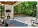 Beautiful outdoor living space with a fireplace, TV, basketball hoop and a lush backyard backdrop at 3290 Camellia Ln, Suwanee, GA 30024