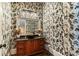 Unique powder room featuring an intricate wallpaper design, granite countertop, vessel sink, and designer accents at 3290 Camellia Ln, Suwanee, GA 30024