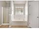 Bright bathroom featuring separate shower and tub with tile floor and a window at 11151 Aliyah Dr, Hampton, GA 30228