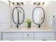 Bathroom with a double vanity, white cabinets, quartz countertop, and oval mirrors at 1934 Westwood Sw Ave, Atlanta, GA 30310