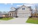 Charming home featuring a two-car garage, well-kept lawn and traditional architectural details at 214 Strawberry Ln, Woodstock, GA 30189