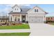 Charming home featuring a two-car garage, well-kept lawn and traditional architectural details at 214 Strawberry Ln, Woodstock, GA 30189